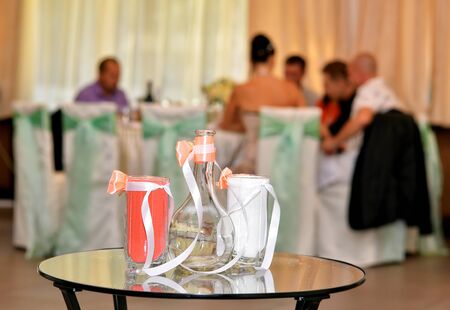 The carafe and two glasses with colored sand on glass tableの写真素材