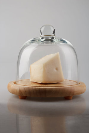 a piece of white cheese in a glass cheese domeの写真素材
