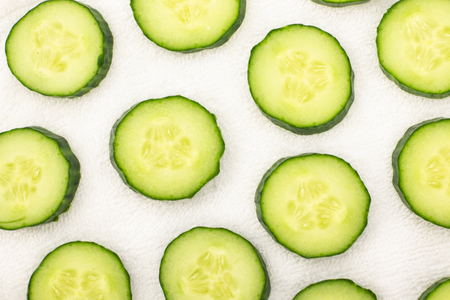 Background from sliced cucumbers on a white towelの写真素材