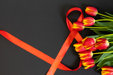 Background with flowers tulips and 8 ribbon on black background.の写真素材