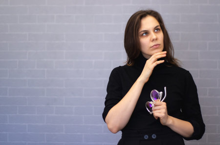 Young woman with a glasses on a hand thinking about business.