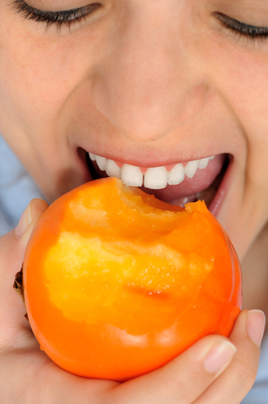 Girl Eating persimmonの写真素材