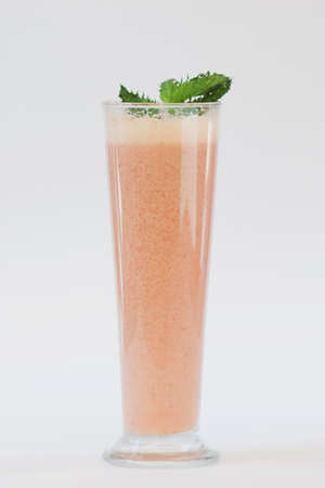 smoothie orange colour in tall glass on white backroundの写真素材