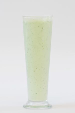 smoothie green colour in tall glass on white backgroundの写真素材