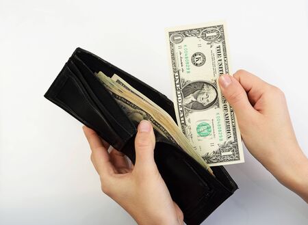 Person taking one dollar bill money from black walletの写真素材