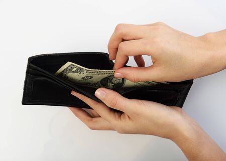Person taking one dollars bill money from black walletの写真素材