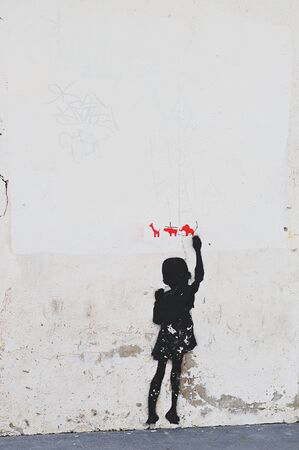 Graffiti of boy drawing animals on white wallの写真素材