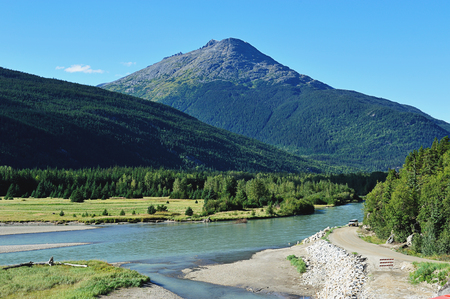 road next rocs and meadow in Alaskaの写真素材