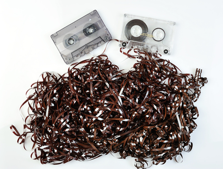 tape casettes on white background with curved tapeの写真素材