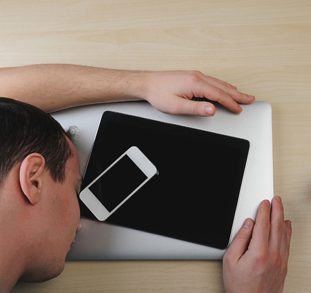 Guy sleeping and give hug to laptop on wood tableの写真素材