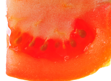 tomato seed cut vivid slice isolated on whiteの写真素材