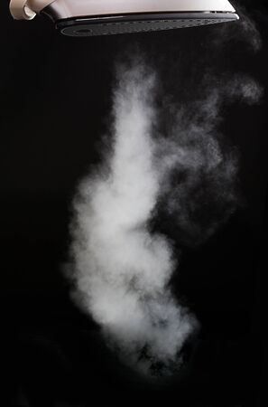 long steam cloud coming from iron on blackの写真素材