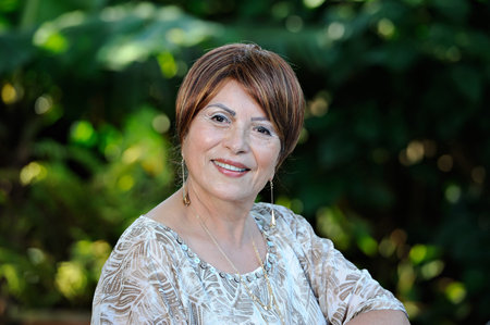 headshot of old smiling woman in green parkの写真素材