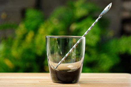 empty smoke glass with spoon on table green park backgroundの写真素材