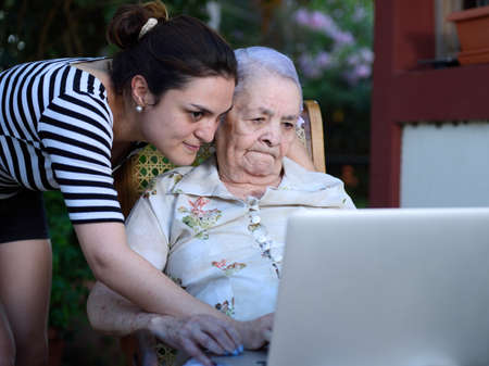 girl and grandma look into modern laptopの写真素材