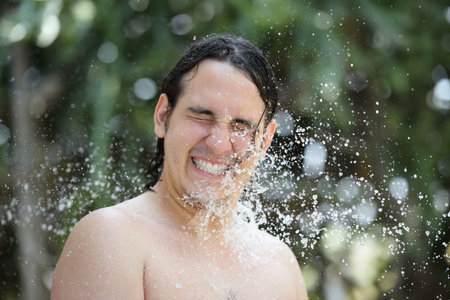 man around water drops in green blur backgroundの写真素材