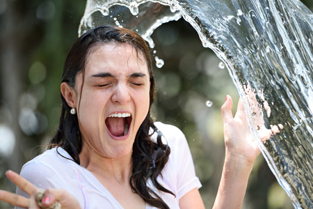 water splash on girl face on blur green backgroundの写真素材