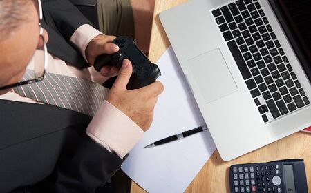 business man play games on working deskの写真素材