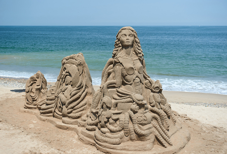 abstract sand statue on beach with ocean on backgroundの写真素材