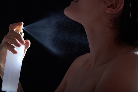 sexy young woman with perfume isolated on black backgroundの写真素材