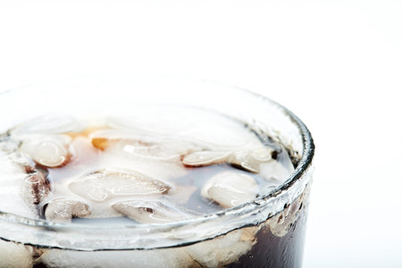 close up of ice with coke in glass isolated on white