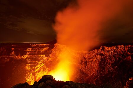 orange glow coming from volcano crater  at nightの写真素材