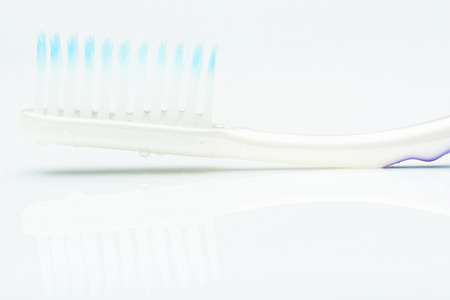 macro of water drops on tooth brush isolated on whiteの写真素材