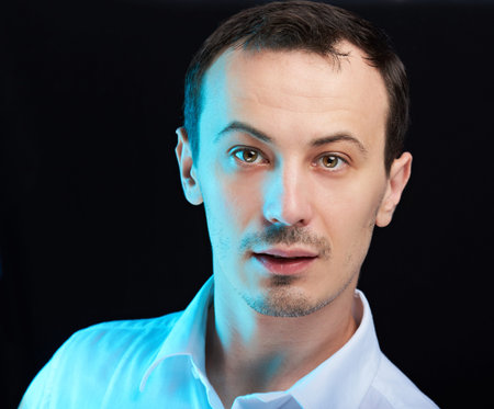 close up portrait  of young white man on black