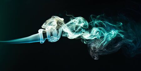 colourful curly smoke isolaetd on black backgroundの写真素材