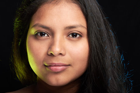 headshot of young latino girl isolated on black