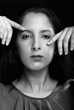young girl with hands next to face in black and white