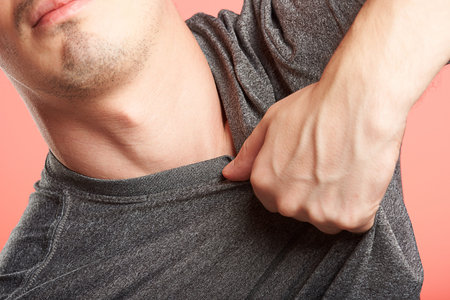 close up of hand grabbing man shirt on pink background