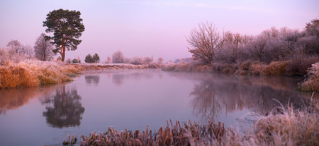 Misty autumn sunrise on a lake in cold frosty morning