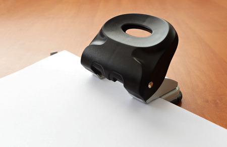 Hole puncher with paper on wood office tableの写真素材