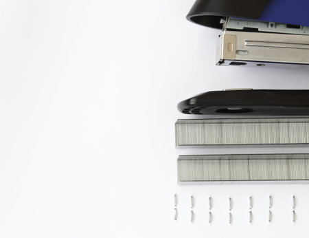 Blue stapler and staples with paper on wood table