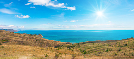 Calm summer day on the seaside with blue sky and sunの写真素材