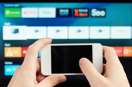 using smartphones as tv remote on blured backgroundの写真素材