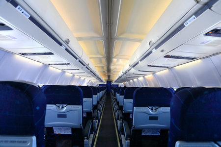 Airplane interior with blue seats and white panel