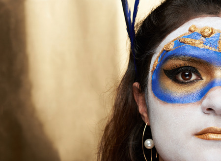 half face of woman with blue and golden maskの写真素材