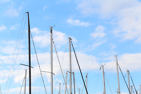 Masts of sailing boats in blue sky background