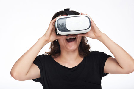 Surprised woman watching virtual reality movie isolated on white background