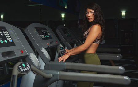 hispanic sexy young woman walk in gym treadmill. Girl working out in fitness club