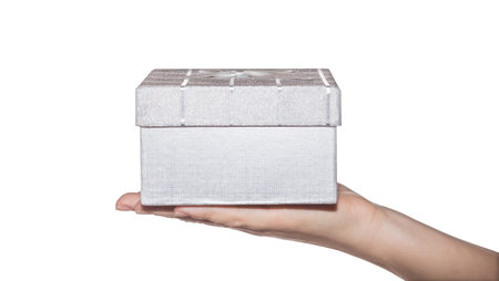 Gift box  in woman hand isolated on white background. Silver gift box in hand.の写真素材