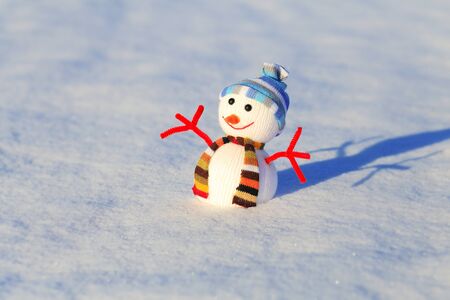 Snowman on white snow. Bright Christmas background with snowman. Snowman on blured snowy backdrop.の写真素材