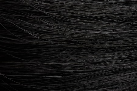 Dark hair background closeup. Texture of woman black hairの写真素材