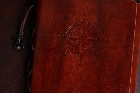 Brown navigation journal with leather texture cover on wooden tableの写真素材