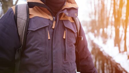 Man in jacket on sunny natural background. Close up of body in jacket outdoors. Nice travel concept.の写真素材