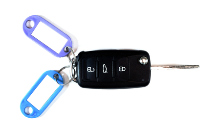 Close up car ignition key isolated on white background. Black car key with color labels. Free space for text on white labels on tags. Car selling concept.の写真素材