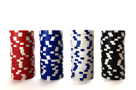 Casino chips in column isolated on white background. Four columns of color chips over white backdrop. Online casino concept.の写真素材