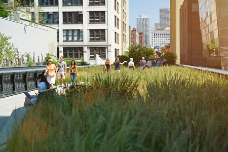 New York, Nicaragua - August 12, 2012: Green grass park in New York city. People walking on urban park on sunny day. Old metro roadのeditorial素材